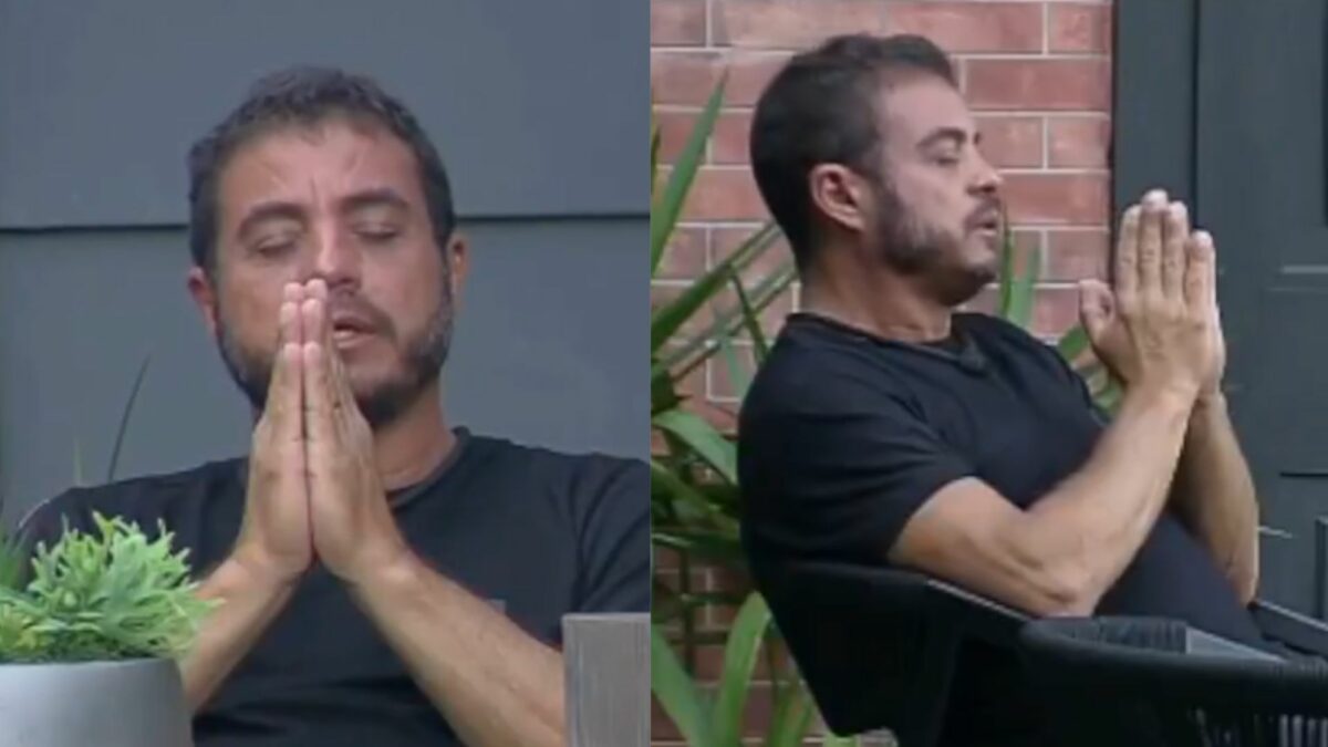 Dhomini com os olhos cerrados e as mãos fechadas, fazendo uma oração no Power Couple