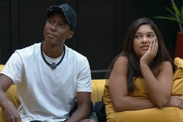 Emilyn e Neguinho sentados no sofá do Power Couple
