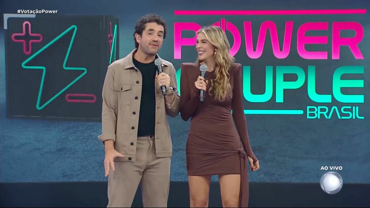 Felipe Andreoli sorrir ao lado de Rafa Brites no palco do Power Couple Brasil 7