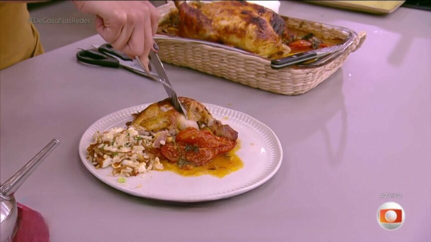 Mulher corta Frango assado ao vinho branco em cima do prato, na mesa do É de Casa