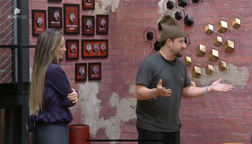 Gi e Eros Prado em frente ao quatro da divisão de quartos no Power Couple Brasil 7