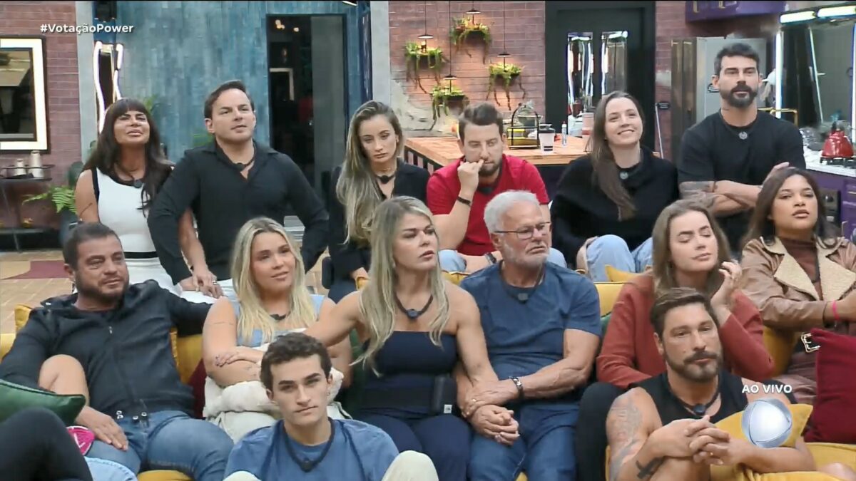 Participantes reunidos na sala, com Gretchen e Esdras, Gi e Eros e Carol e Radamés sentados no banquinho da DR no Power Couple