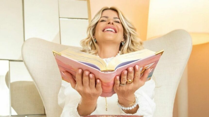 Karina Bacchi sorridente, segurando uma bíblia nas mãos