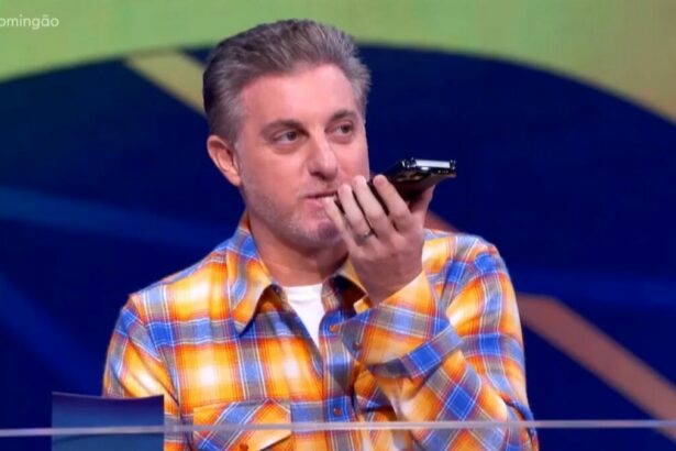 Luciano Huck atendendo o celular durante gravação do Domingão