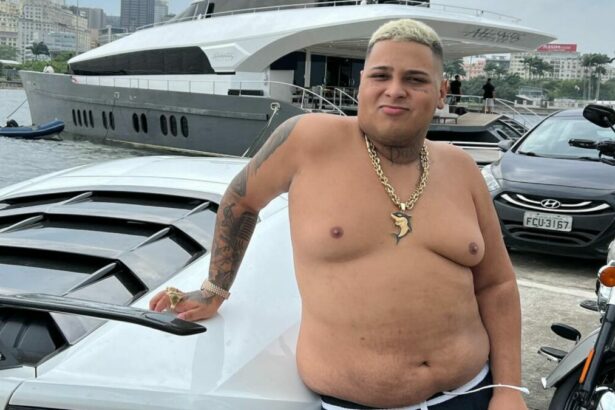 MC Ryan SP, sem camisa, em foto posada ao lado de um carro
