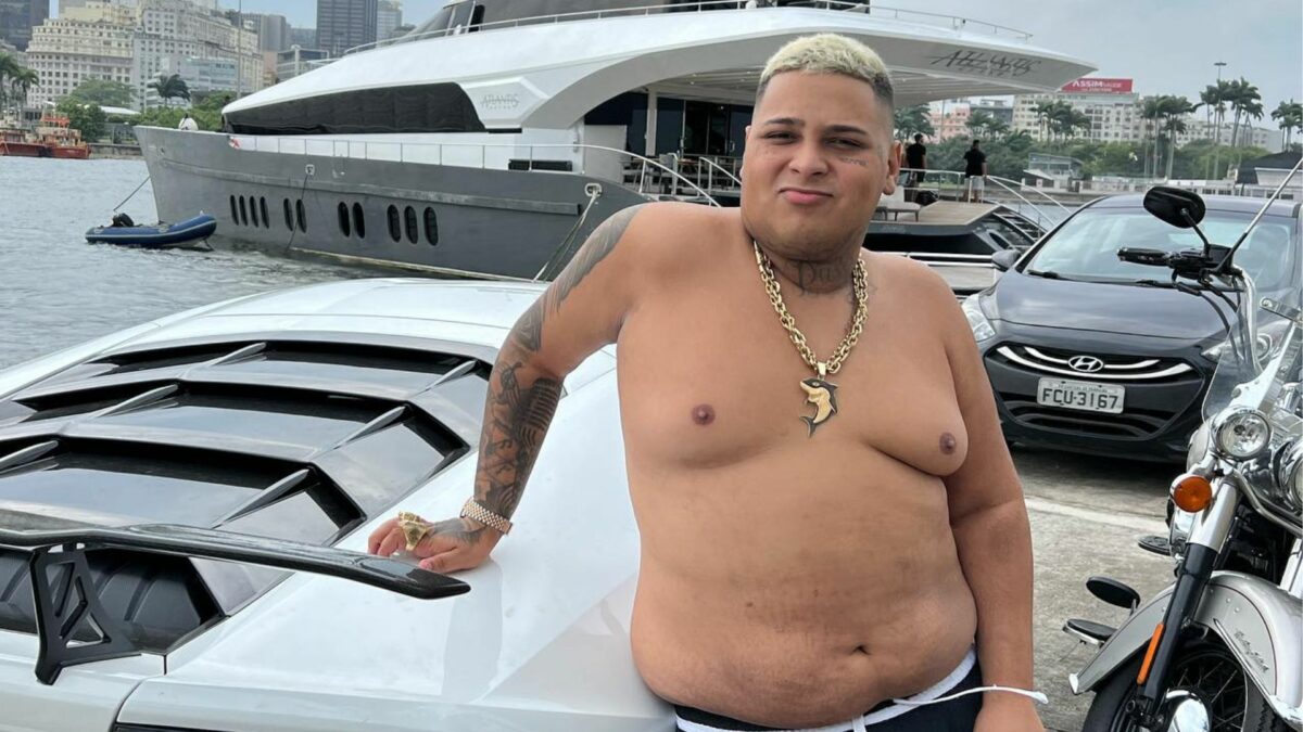 MC Ryan SP, sem camisa, em foto posada ao lado de um carro