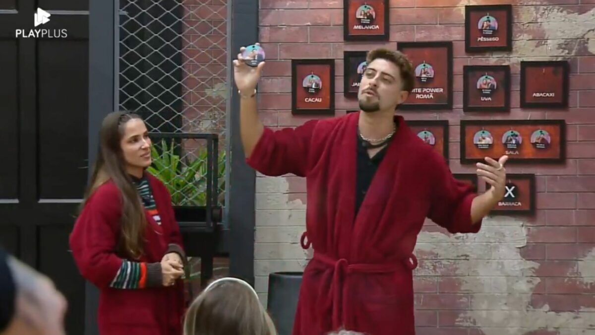 Nat e Eike em frente ao quadro da divisão de quartos no Power Couple Brasil 7