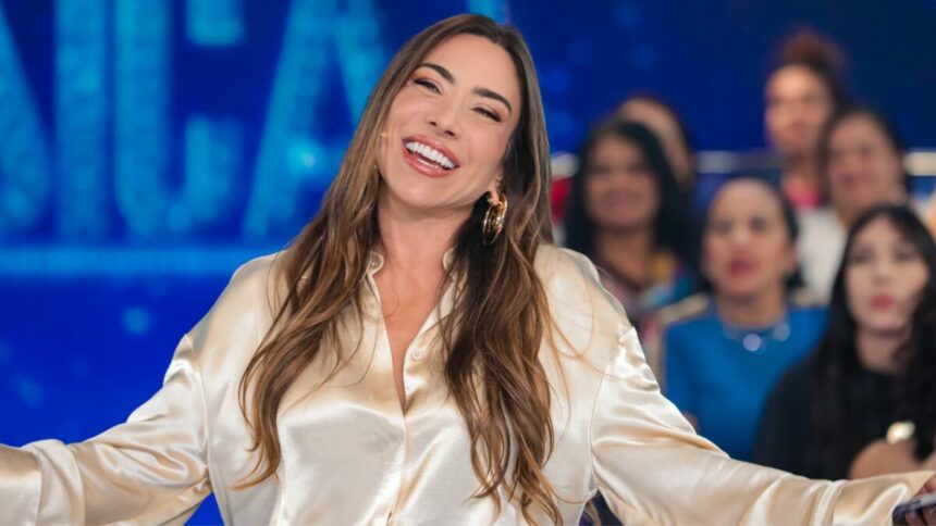 Patricia Abravael sorridente no cenário do Programa Silvio Santos