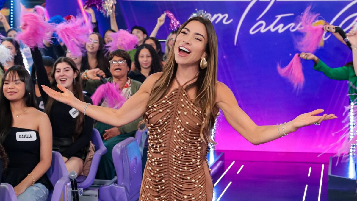Patricia Abravanel, sorridente e com os braços abertos no Programa Silvio Santos