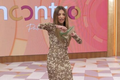 Patrícia Poeta com um sapato na mão no cenário do Encontro