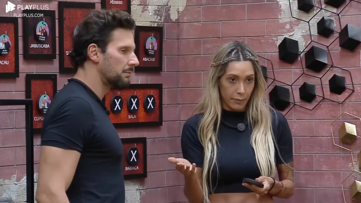 Pessina e Talira em frente ao quadro da divisão de quartos no Power Couple Brasil 7