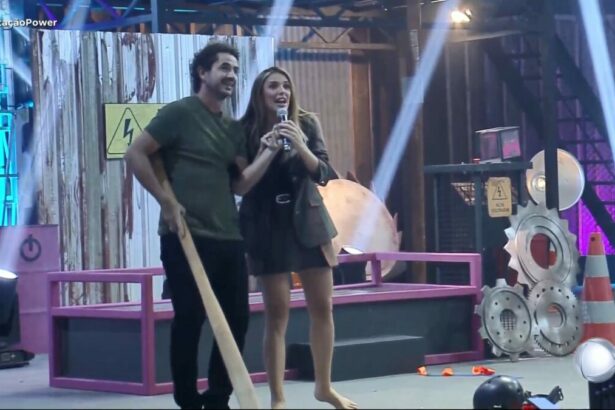 Rafa Brites e Felipe Andreoli, com um bastão em mãos, em trecho de prova do Power Couple Brasil 7