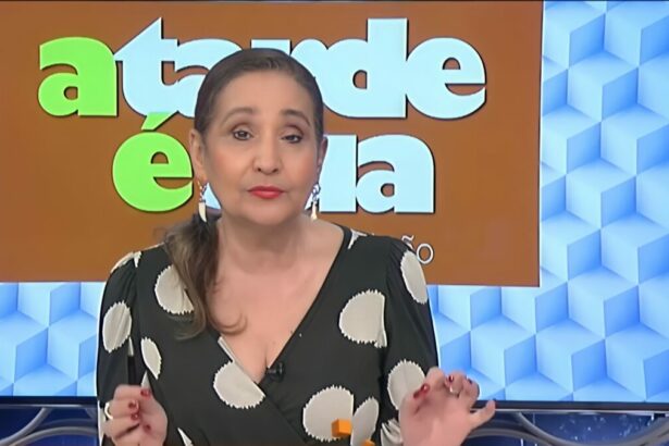 Sonia Abrão na bancada da RedeTV! com blusa preta e branca