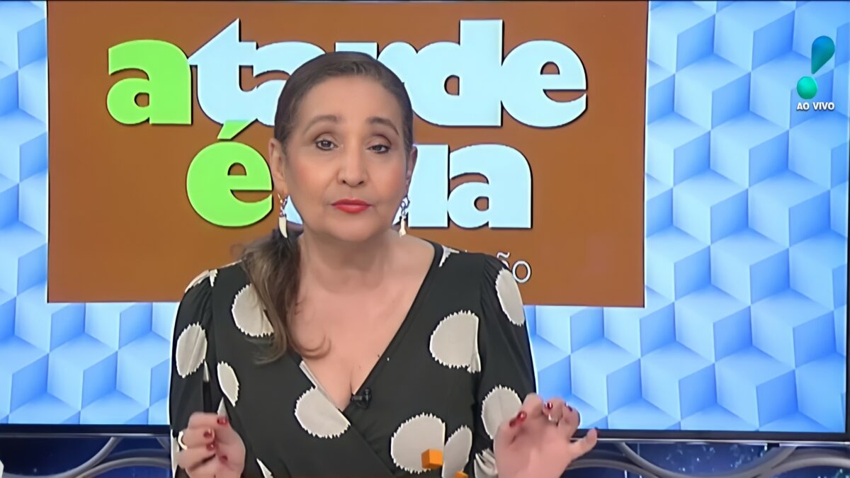 Sonia Abrão na bancada da RedeTV! com blusa preta e branca