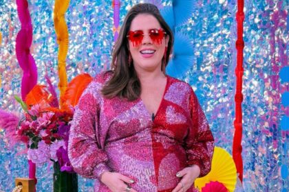 Tati Machado com a mão na barriga de grávida