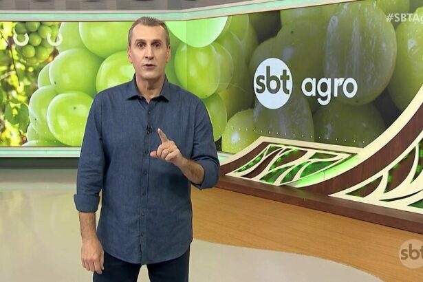 Sandro Ivanowski de camisa azul escura no cenário do SBT Agro que apresenta uvas no telão