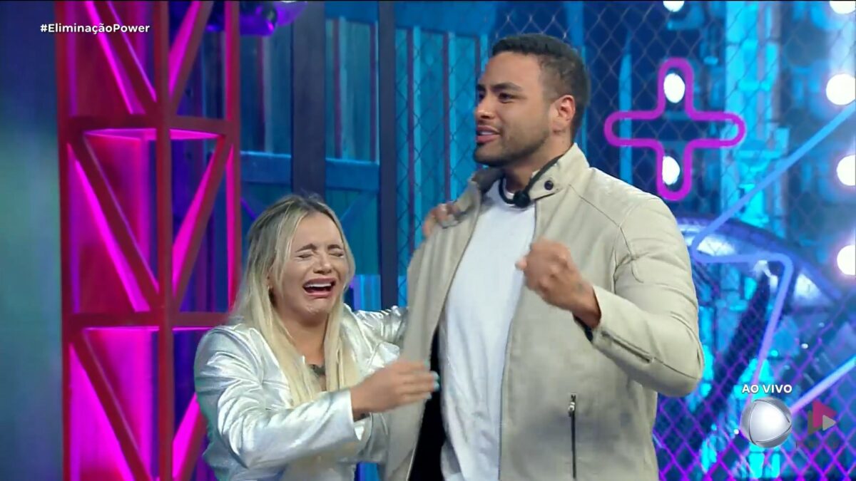 Ana Paula chorando ao lado de Antony no palco do Power Couple Brasil 7. Eles vestem roupas claras
