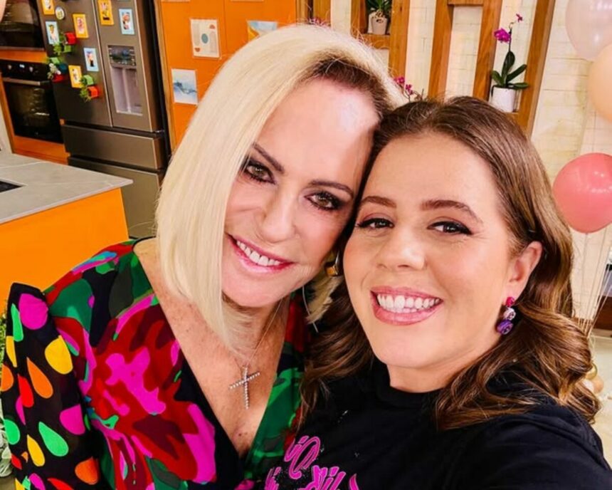 Ana Maria Braga sorrir abraçando Tati Machado em uma selfie no cenário do Mais Você