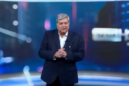 Datena em pé no cenário do Tá na Hora (SBT), ele veste terno preto e sem gravata, parece estar sorrindo e feliz, 6 meses antes de assinar com a RedeTV!
