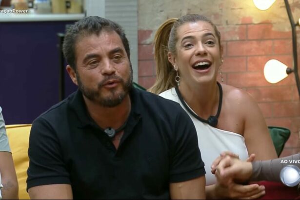 Dhomini e Adriana sorridentes no sofá do Power Couple Brasil 7