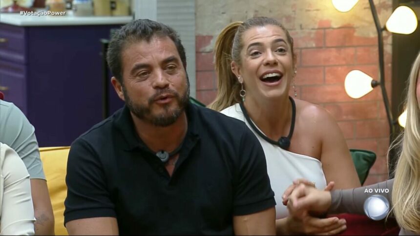 Dhomini e Adriana sorridentes no sofá do Power Couple Brasil 7