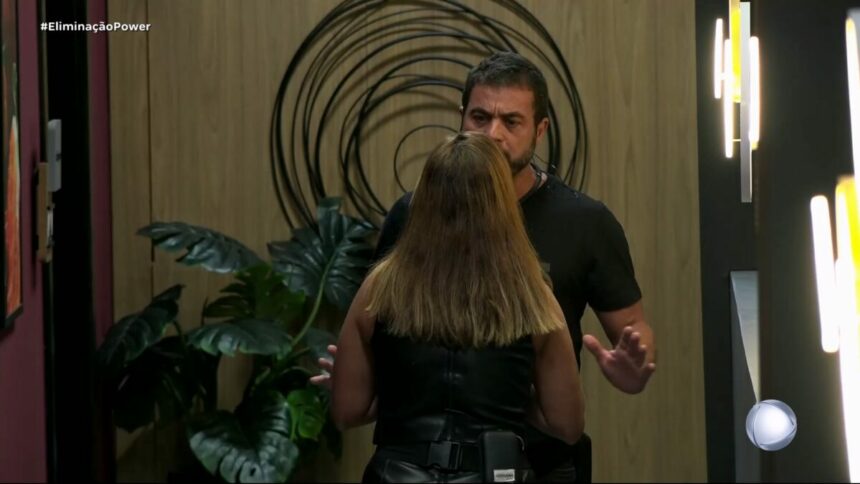 Adriana olha para Dhomini que gesticula com as mãos com raiva no corredor do Power Couple Brasil 7