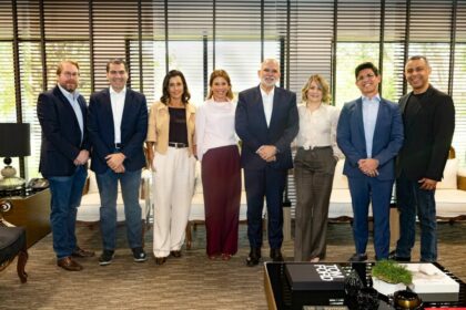 Daniela Beyruti ao lado de executivos da RECORD e SBT. Eles estão em pé abraçados e sorridentes na sede da RECORD na Barra Funda
