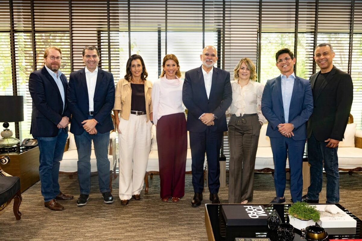 Daniela Beyruti ao lado de executivos da RECORD e SBT. Eles estão em pé abraçados e sorridentes na sede da RECORD na Barra Funda