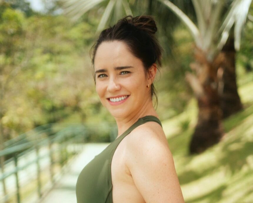 Fernanda Vasconcellos de top verde em um lugar que parece ser um resort