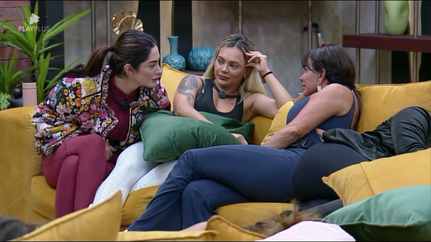Fran, Ana Paula e Gretchen sorrindo de Talira sentadas no canto do sofá da Mansão do Power Couple Brasil