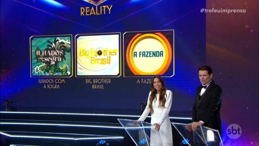 Logo do reality Ilhados Com a Sogra ao lado do BBB 24 e de A Fazenda no telão do Troféu Imprensa