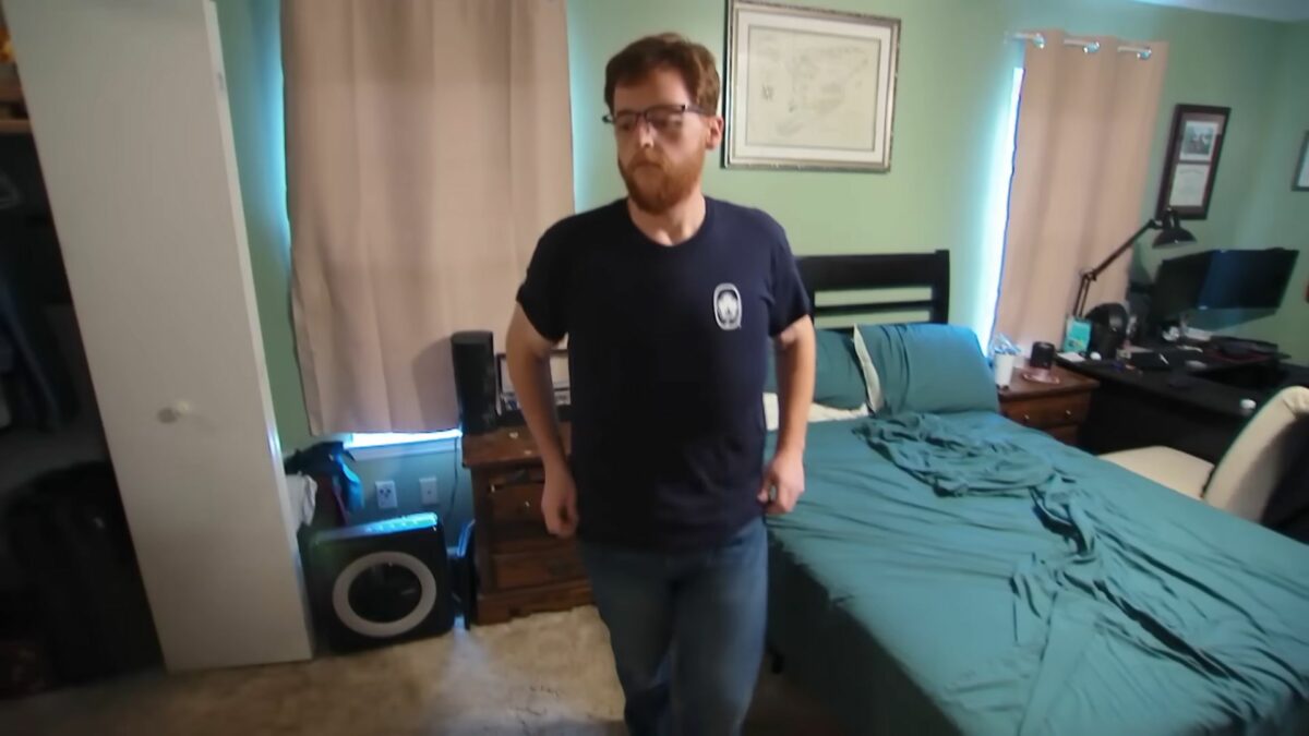 Justin veste camisa preta e caminha para a cozinha de sua casa