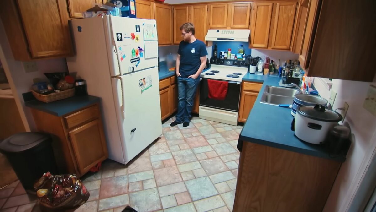 Justin em pé, mais magro, na cozinha após participar do Quilos Mortais