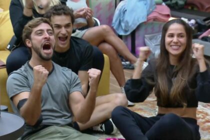 Eike e Nat gritam e fazem sinal de comemoração sentados na sala da Mansão Power Couple Brasil 7 antes do veto em Silvia e André