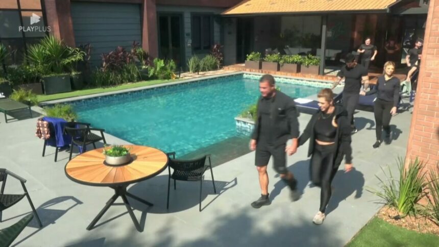 Casais caminham ao lado da piscina da Mansão Power Couple Brasil 7 para ir para o campo de Provas