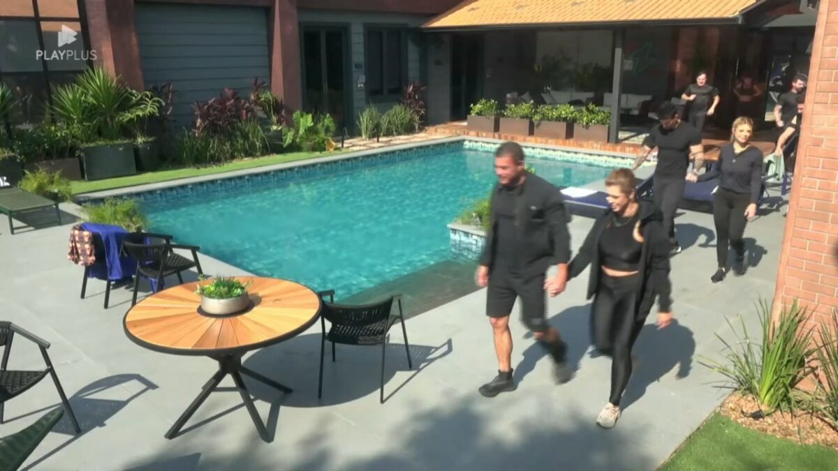 Casais caminham ao lado da piscina da Mansão Power Couple Brasil 7 para ir para o campo de Provas