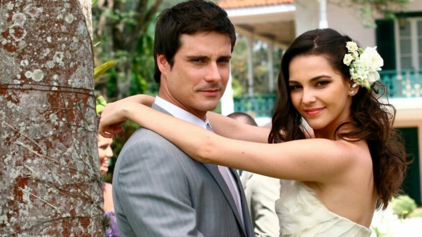 Lucas (Sérgio Abreu). e Victória (Tainá Müller) se abraçam em cena de casamento na novela Revelação