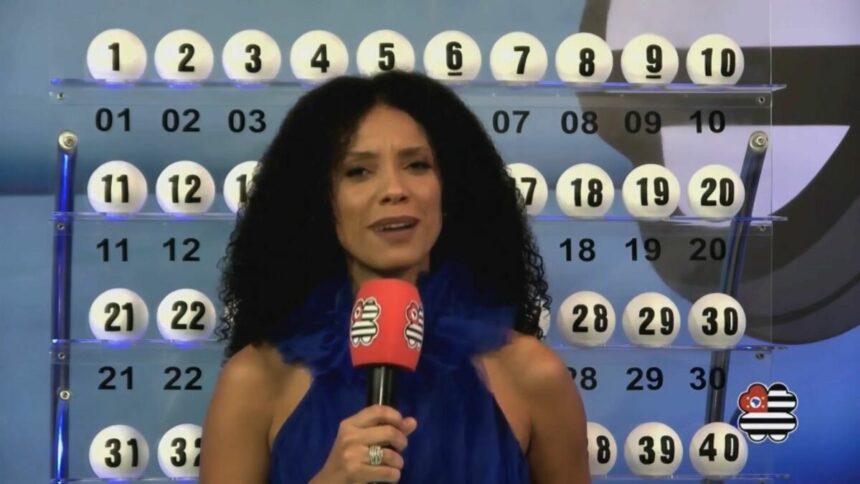 Apresentadora do São Paulo dá Sorte em frente ao painel com as bolas do sorteio do dia 04 de maio de 2025