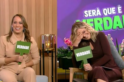 Renata Alves segura plaquinha de "Verdade" ao lado de Ticiane Pinheiro que gargalha, também segurando a plaquinha no cenário do Hoje em Dia