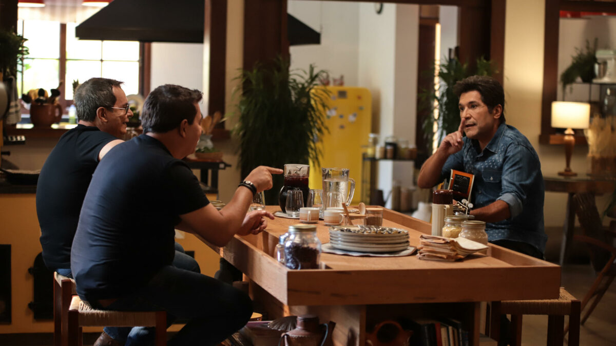 Althair & Alexandre sentados a mesa na frente do cantor Daniel em uma fazenda na gravação do Viver Sertanejo