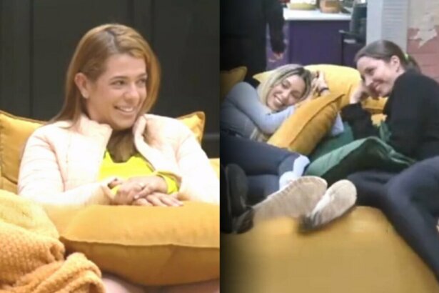 Adriana sentada no sofá da Mansão do Power Couple e sorrindo para Carol que está na outra ponta