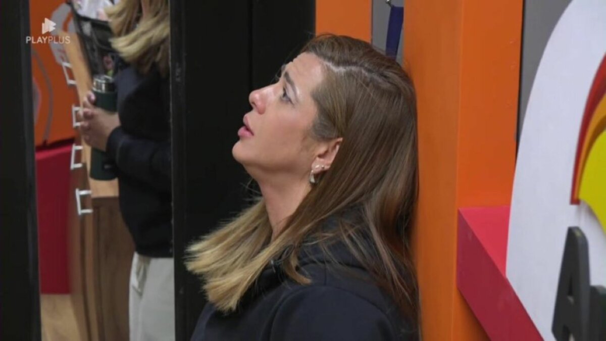 Adriana, em momento de reza na parede, em expressão triste, na despensa do Power Couple