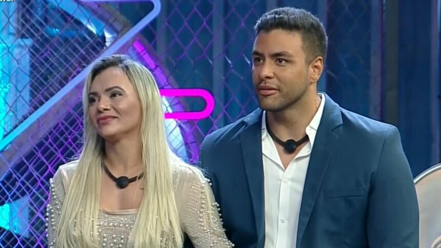 Ana Paula e Antony sentados no palco no Power Couple
