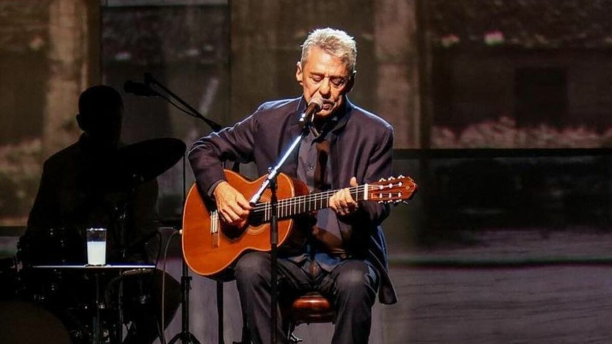 Chico Buarque tocando violão em trecho de show