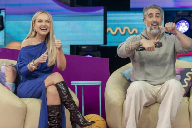 Eliana e Marcos Mion, sorrindo, sentados lado a lado, no cenário do Caldeirão