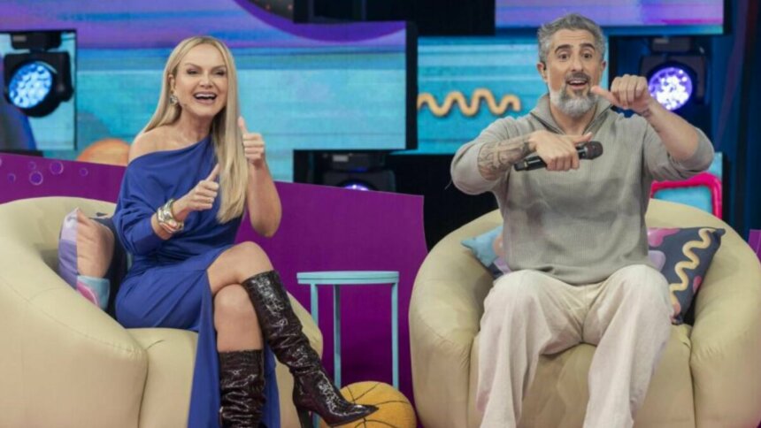 Eliana e Marcos Mion, sorrindo, sentados lado a lado, no cenário do Caldeirão