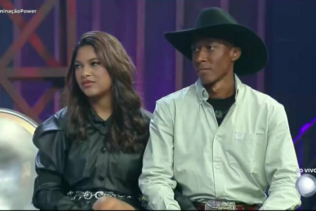 Emilyn e Neguinho sentados no palco do Power Couple