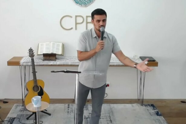 Felipe Simas, de roupa social, em trecho de pregação em igreja evangélica