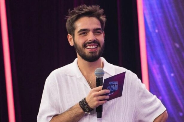 João Guilherme Silva com microfone e ficha nas mãos, em trecho do Programa do João na Band