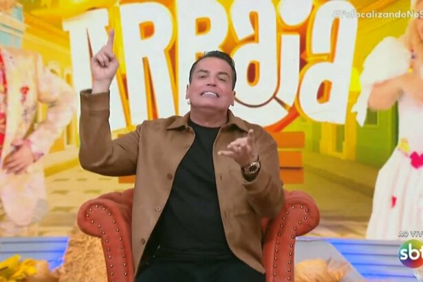 Leo Dias levanta o dedo para cima enquanto apresenta o Fofocalizando no SBT
